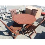 A teak octagonal garden table with four chairs.