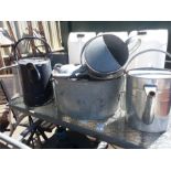 Various galvinized watering cans,chicken feeders and a tub.