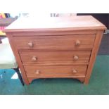 A pine chest of three drawers.