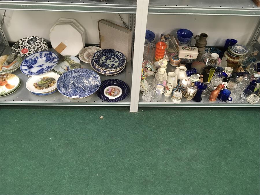 A large quantity of mixed china, glass, plates etc. on two shelves.