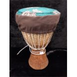A small wooden carved African tribal Bongo drum with fabric cover.