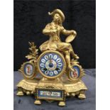 A French gilded mantel clock with porcelain dial and panels.