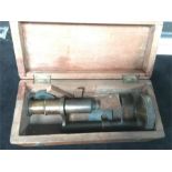 An antique binocular brass small microscope in wooden box.