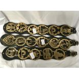 Three horse brasses on leather straps.