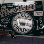 A metal sign depicting Pilsner Urquell and a brass tray.