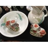A Victorian toilet jug and basin and a pair of Staffordshire design animal ornaments.