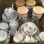 A box of china cups and plates, together with Portmeirion storage jars.