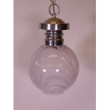 A contemporary chrome pendant light, with a swirled glass shade, 24" drop