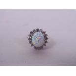 A lady's silver dress ring set with a large opalite encircled by cubic zirconia, approximate size '