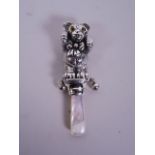 A silver baby's rattle in the form of a teddy bear with mother of pearl handle, 3½" long