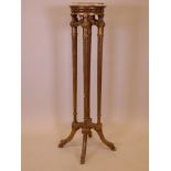 An early C20th giltwood jardiniere stand, raised on fluted columns and carved hoof supports (lacks