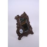 A cast bronzed metal easel clock and mirror with scrolling swag and floral decoration, 9" x 7½"