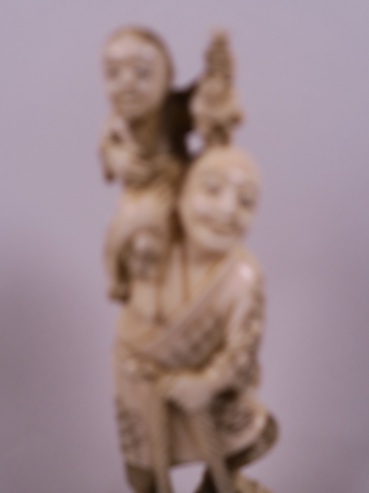 A Japanese carved marine ivory figurine of a farmer with a small child on his shoulder, a basket - Image 2 of 4