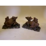 A pair of Oriental wood carvings of boys riding water buffaloes, A/F, 9" long