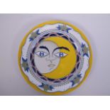 A polychrome porcelain cabinet plate decorated with a sun and moon to the centre, Cyrillic script