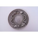 A Chinese white metal coin dish with repoussé dragon decoration, 4" diameter