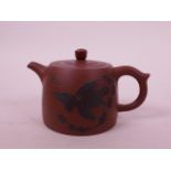 A Chinese Yixing teapot with carved eagle decoration, character inscription verso, impressed mark to