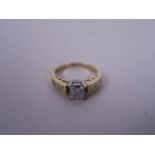 A 14ct yellow gold diamond ring, the central princess cut diamond of 70 points, with diamond set