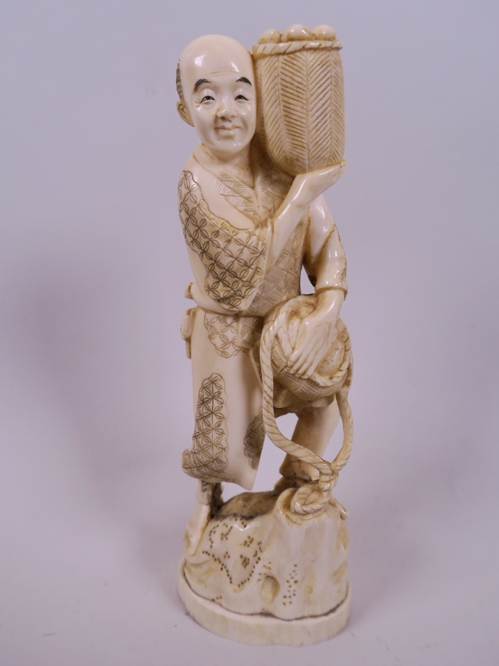 A Japanese marine ivory carving of a farmer with two baskets of vegetables, 7½"