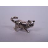 A novelty silver figure of a cat with emerald set eyes, 1½" wide