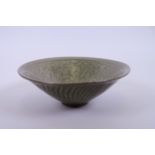 A Chinese Song style pottery bowl with olive green glaze and raised decoration of boys and