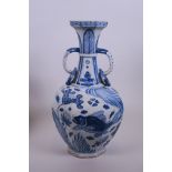 A Chinese Ming style blue and white pottery vase with two handles and decorated with carp in a lotus