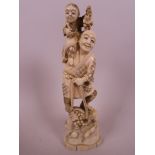 A Japanese carved marine ivory figurine of a farmer with a small child on his shoulder, a basket