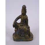 A Chinese bronze figure of Quan Yin seated on a plinth, with a gilt patina, 5" high