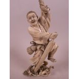 A Japanese carved ivory figurine of a fisherman with an oar and catch, and a monkey at his feet,