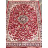 A Kashmiri red ground carpet with floral design and central medallion, 98" x 64"