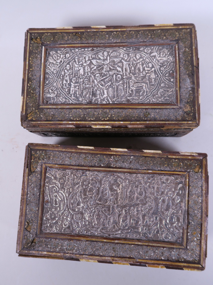 A pair of antique Indo-Persian cigarette boxes with silver plated panels embossed with many
