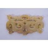 A Chinese carved jade pendant with archaic style dragon and phoenix decoration, 3½" wide