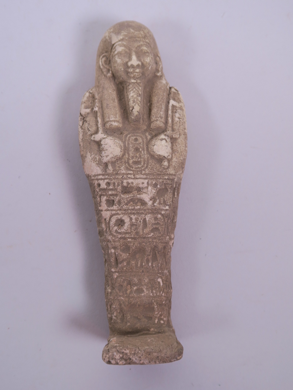 An Egyptian terracotta shabti with impressed hieroglyphic inscriptions, 6" high