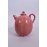 A Chinese pink glazed pottery teapot in the form of a gourd with character inscription to side,
