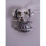 A silver brooch in the form of a dog with glass inset eyes, 1" wide