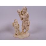 A Japanese carved ivory figurine of a traveller with two children, 5½" high