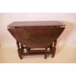 A small early C19th oak gateleg table with oval top on turned supports and single frieze drawer,