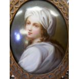 A C19th portrait miniature painted on porcelain, 3" x 2½", set in an elaborate carved wood easel