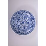 A Chinese blue and white porcelain charger with scrolling floral decoration, 12" diameter, seal mark