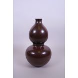A Chinese double gourd shaped porcelain vase with an iridescent rust glaze, impressed seal mark to