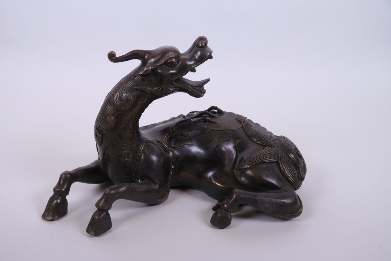 A Chinese bronze censer and lid in the form of a horse, 9½" long