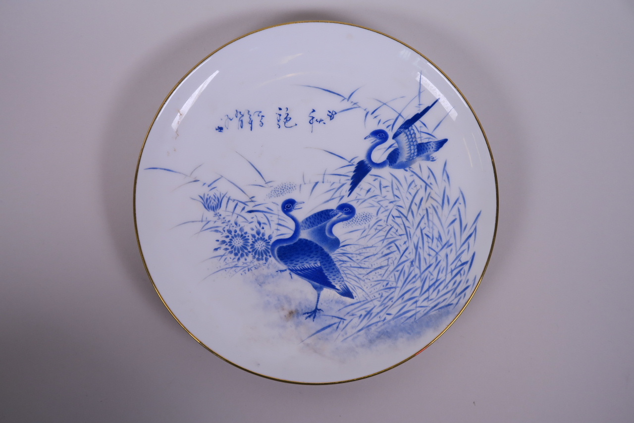 An Oriental blue and white porcelain cabinet plate with a gilt rim and waterfowl decoration,