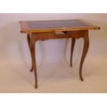 A C19th Continental fruitwood writing table, with inset leather top, raised on shaped supports (