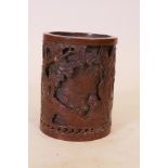 A Chinese bronze brush pot with raised and pierced decoration of figures playing chequers under a
