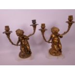A pair of C19th gilt bronze two branch candelabra in the form of cherubs holding cornucopia, on