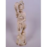 A Japanese carved marine ivory figurine of a fisherman with cormorant and fish, 8½ " high