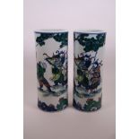 A pair of Chinese famille verte cylinder vases decorated with warriors in training, 6 character mark