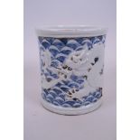 A Chinese blue and white porcelain brush pot with raised decoration of a dragon and carp,