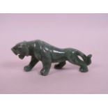 An Oriental carved green hardstone figure of a tiger, 5" long