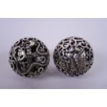 A pair of Chinese white metal meditation balls with pierced dragon and phoenix decoration, 2"